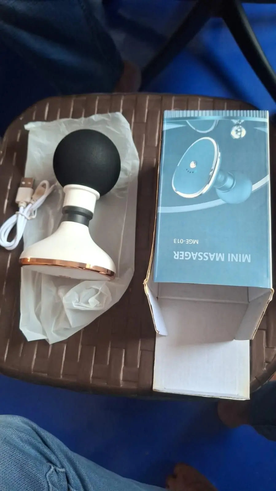 Mini portable body massager with USB charging cable and original box for relaxation on-the-go