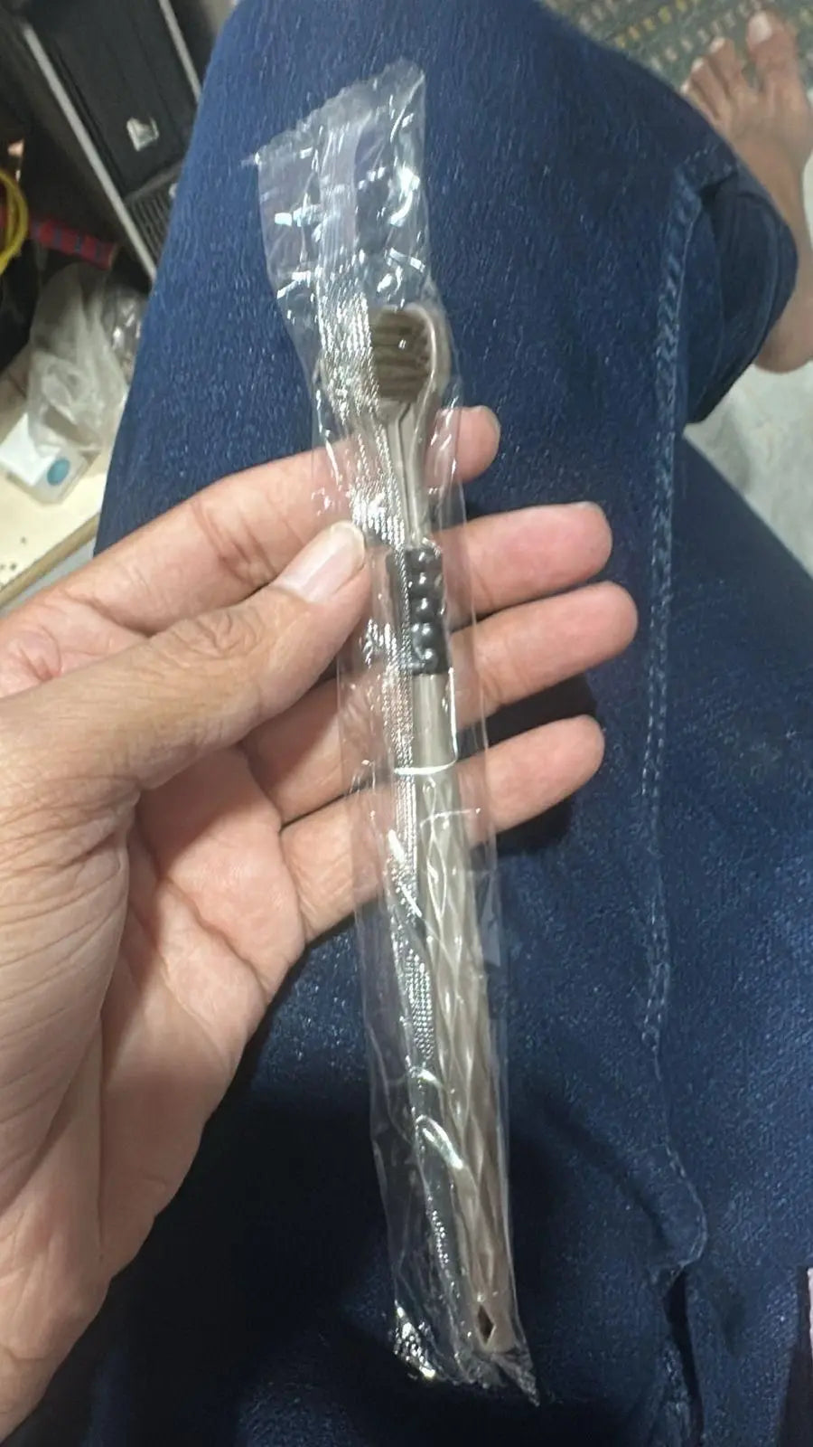Multi-angle toothbrush pack in transparent packaging held in hand for effective dental care