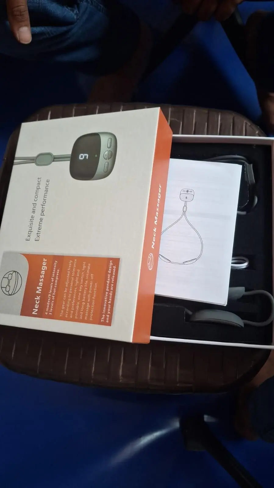 Portable neck massager packaged with user manual and control panel for soothing neck relief